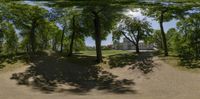 a 360 - panorama is shown through some trees and leaves on a path near a house