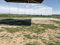 a picture of a glass pavilion over looking a farm field with a sky background and some cars