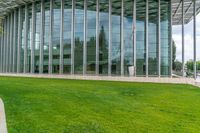 a building with many windows and grass outside it that is very large and well maintained