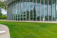 a building with many windows and grass outside it that is very large and well maintained