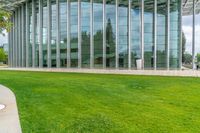 a building with many windows and grass outside it that is very large and well maintained