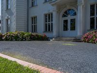 a large white house with a stone walkway leading up to the door and a blue fire hydrant at the end of one lane