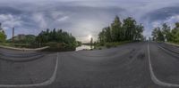 this is a fish eye lens showing a country road with a river running down it