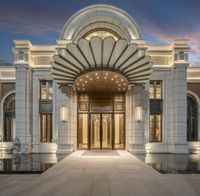 the entrance to this hotel is beautifully lit up at dusk with its dramatic decor and large round archway