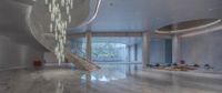 the large lobby is decorated with white marble, a spiral staircase leads into the second floor