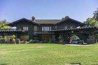 a large house on a lush green lawn with a car parked in the driveway of it