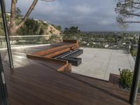 a deck with a fire pit on it and a balcony and overlooking the city below