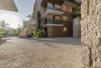 the walkway leading up to a luxury villa building with an outdoor area for seating and a balcony