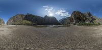 a beach has rocks and water in the sand area and some green shrubs and trees