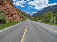 the red rocks are high up on the side of the road and it is an amazing color