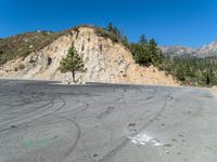 a road that has some traces in it and mountains behind it in the background,