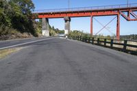 the red bridge is above the road and it is overpassed on either side