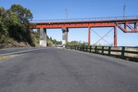 the red bridge is above the road and it is overpassed on either side