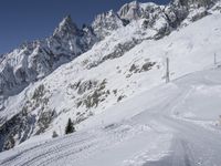 a man skiing down a slope on a mountain side at a ski resort on the slopes