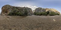 an image of two rock formations on the shore of a lake with water on the shore