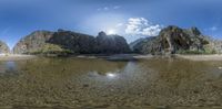 a 360 - view of mountains and the sun in the sky in a lake that is on the ground