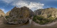 the view shows a narrow canyon and its surrounding mountains of varying heights of cliffs