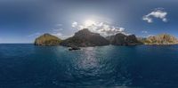 a view of the sun over a small island with three big rocks in the water