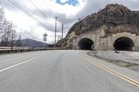 two tunnels are shown side by side on the road in front of a mountaintop
