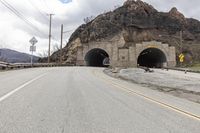 two tunnels are shown side by side on the road in front of a mountaintop
