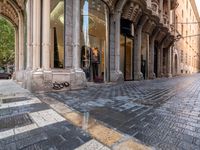 people in the street with clothes in store front window display windows and cobbles on either side