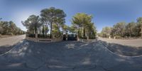 a fisheye lens photo of an entrance into an outside lot with a lot of trees in the background