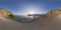 a panoramic picture of a beach and ocean below it, taken with the fisheye lens