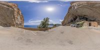 a van parked near a cave by the ocean while looking at it in a 360 - lens mirror