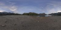 this is a 360 view of a body of water with mountains in the background and water being stirred over to shore