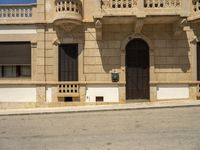 a stop sign at the corner of a deserted street in front of a building that has balconying