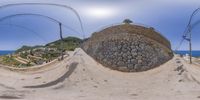 two views of a half pipe in the air on a hill next to an ocean