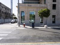 the fire hydrant is on the sidewalk next to a large building with a glass door