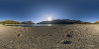 a scenic shot of the mountains and water below it, taken with 360 - pane lenses