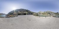 a 360 - view photo shows the mountain range below with a small lake near it