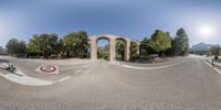 the view from the outside looking down at a street and a large archway and a sign