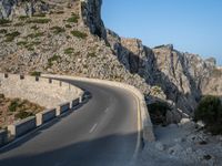 an empty highway winds off into the mountainside in california's cabo mountains