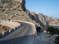 an empty highway winds off into the mountainside in california's cabo mountains