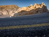 a motorcycle on a mountain road with mountains behind it and no clouds in the sky