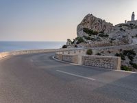 a scenic road stretches into the ocean from the beach with an arched wall surrounding it