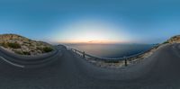 a fish eye lens view of the road leading to the ocean at sunset on a clear day