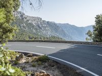 the empty roadway of this mountain road is very scenic and winding on the side of the road