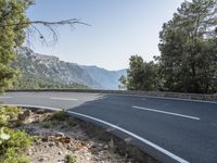 the empty roadway of this mountain road is very scenic and winding on the side of the road