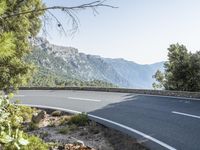 the empty roadway of this mountain road is very scenic and winding on the side of the road