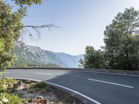 the empty roadway of this mountain road is very scenic and winding on the side of the road