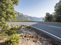 the empty roadway of this mountain road is very scenic and winding on the side of the road