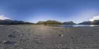 view from a perspective point perspective lens of a beach, mountains and body of water