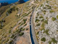 the curve road leads to an ocean view from a high cliff side overlook at rocky coastline and blue water