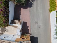 an overhead view of stairs between buildings with trees and a street in the background on top of a driveway