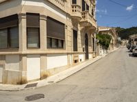 a building with lots of windows is on the side of a road in a narrow alley