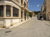 a building with lots of windows is on the side of a road in a narrow alley